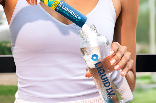 article_image Woman pouring Liquid I.V. Lemon Lime Hydration Multiplier into a water bottle to stay hydrated