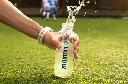 article_image Bottle of Liquid I.V. electrolyte drink on a sports field, showing hydration in action