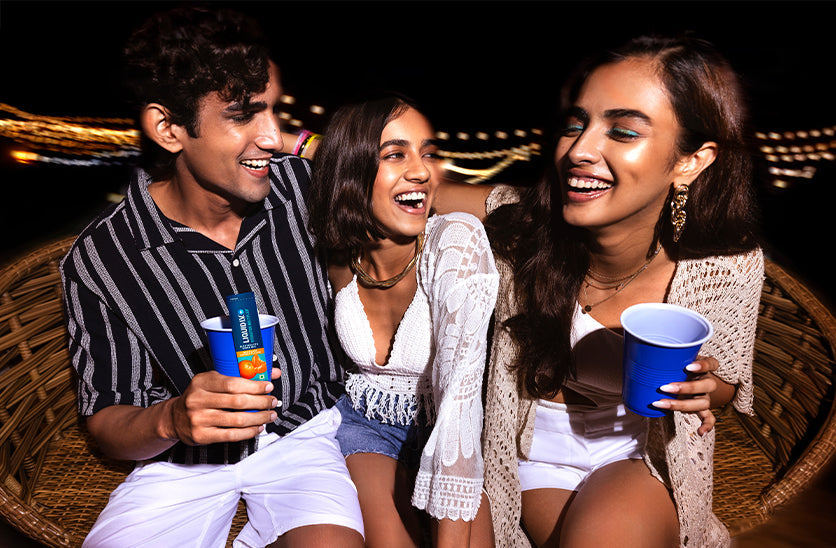 Group of friends laughing at a party, holding Liquid I.V. to ease hangover symptoms
