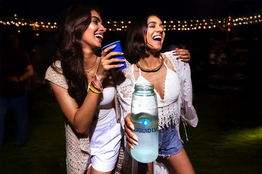 Two women enjoying a night out with Liquid I.V. to stay hydrated and prevent a hangover
